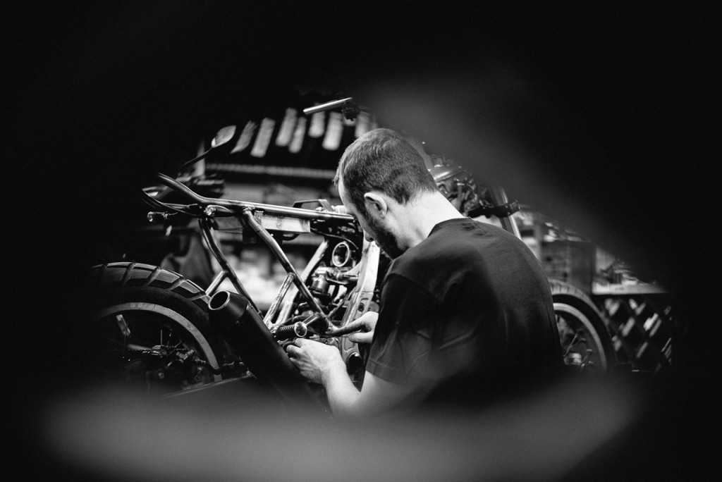 Vue de dos Isidore Delgrosso travaillant sur une moto - Atelier Mécaservices92